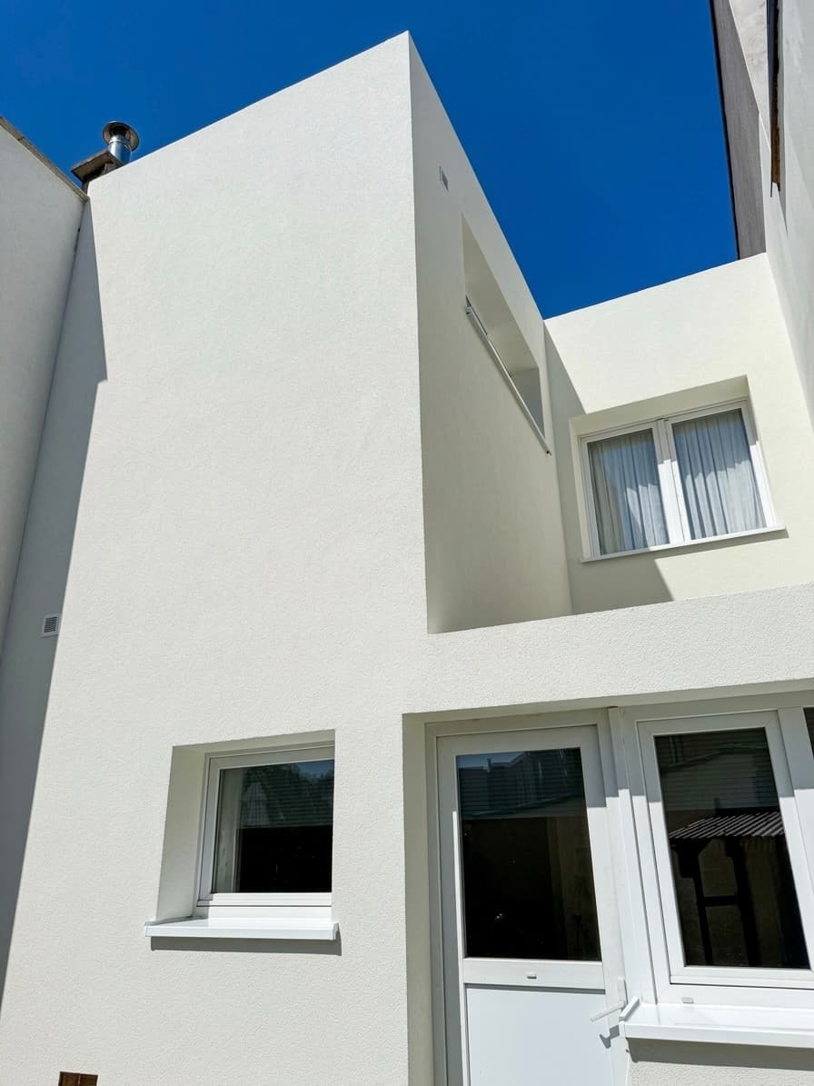 Achtergevel na crepi afwerking — strakke witte gevel