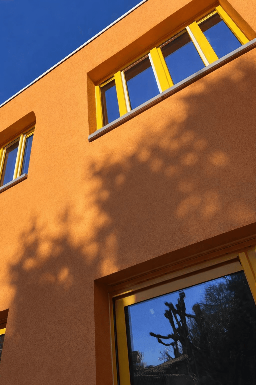 Pomporanjevý fasáda s crepi afwerking — warm oranje eindresultaat
