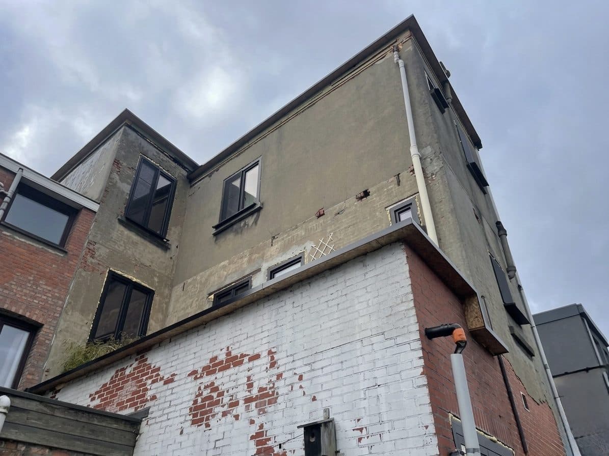 Woning vóór spuitkurk — verweerde cementbepleistering